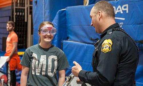 Student in drunk goggles talking to a police officer